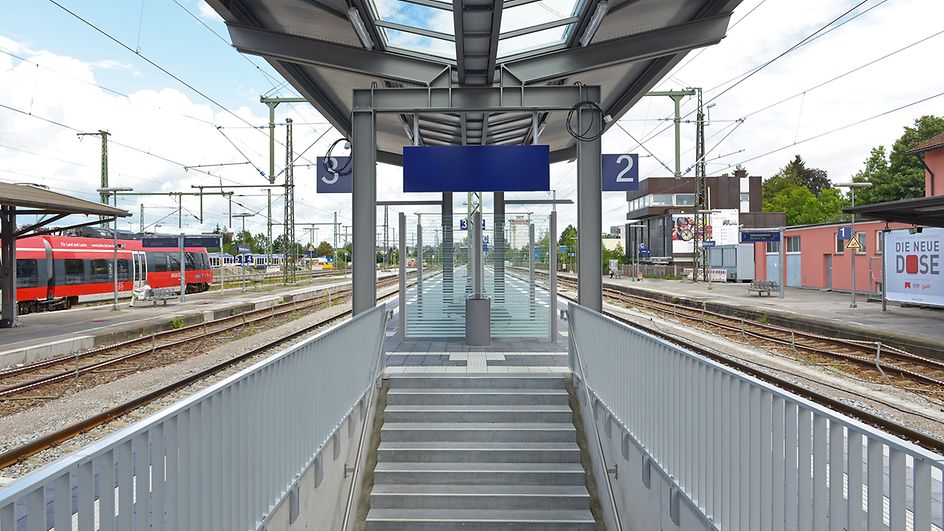 Treppenaufgang einer Verkehrsstation mit überdachtem Mittelbahnsteig